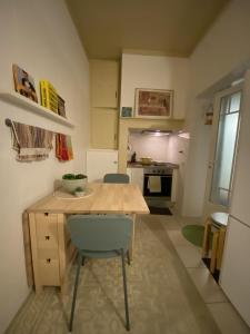 una pequeña cocina con mesa de madera y sillas en JScAsa Rainha Centro, en Caldas da Rainha