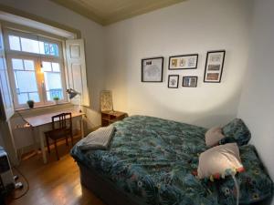 a bedroom with a bed and a desk and a window at JScAsa Rainha Centro in Caldas da Rainha