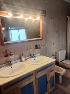 ein Badezimmer mit zwei Waschbecken und einer Toilette und einem Spiegel in der Unterkunft La Fresquita, Castaño del Robledo in Castaño de Robledo