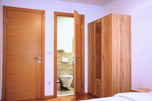 a bathroom with two wooden doors and a toilet at Sarajevo Gate in Sarajevo