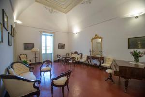 un soggiorno con sedie, tavolo e specchio di Villa De Pietro a Cursi