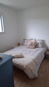 a white bed with pillows on it in a room at Chambre d'hôtes Nova, petit déjeuner en supplément 5 euros par personne in Saint-Pair-sur-Mer
