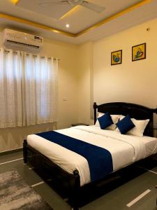 a bedroom with a large bed with blue pillows at Tasya Villa in Udaipur
