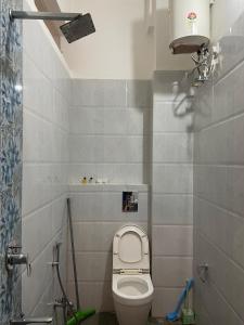 a small bathroom with a toilet and a shower at Tasya Villa in Udaipur
