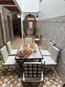 a table and chairs with food on it at Dar Manzakin in Marrakesh +30 photos