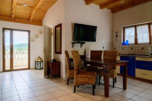 une cuisine avec une table et des chaises et une télévision dans l'établissement Villa I Karma, à Tisno