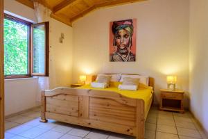 une chambre avec un lit avec un tableau sur le mur dans l'établissement Villa I Karma, à Tisno