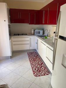a kitchen with red cabinets and a rug on the floor at Casa Sofia in Termoli
