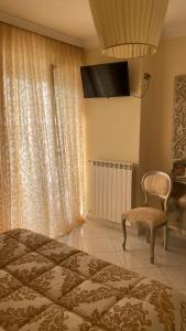 a bedroom with a bed and a chair and a television at Casa Sofia in Termoli
