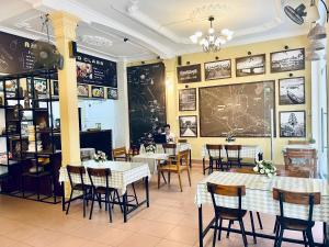 a restaurant with tables and chairs and a chalkboard on the wall at Amy Hostel Hue in Hue