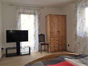 a bedroom with a bed and a television and a cabinet at Moderne 3 Zimmer Wohnung mit separatem Eingang in Hannover