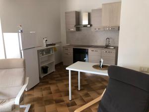 a small kitchen with a white table and a couch at Chira House in Santa Marinella