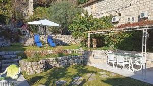 a backyard with a table and chairs and an umbrella at Villa Perast in Perast