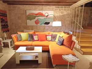 a living room with an orange couch with colorful pillows at Villa Perast in Perast