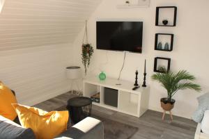 een woonkamer met een flatscreen-tv aan de muur bij Wohlfühl & Schickes Apartment in Heilbronn