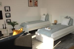 een woonkamer met twee bedden en een bank bij Wohlfühl & Schickes Apartment in Heilbronn