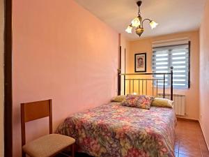 a bedroom with a bed and a chair and a window at Casa Rural Las Condesas in Santo Domingo de Silos