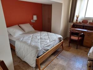 a small bedroom with a bed and a desk at Appartement duplex avec cour extérieure Avignon centre in Avignon