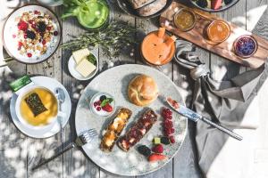 une table garnie d'assiettes de nourriture et de boissons dans l'établissement Hotel Magdalener Hof, à Bolzano 102 autres photos