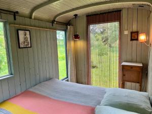 a bedroom with a bed and a window and a door at Wooden Cabin - Outdoor Kitchen - Superb Location! in Capdrot