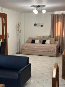 ein Wohnzimmer mit einem Bett und einer Couch in der Unterkunft Peaceful Cottage Porto Rafti in Porto Rafti