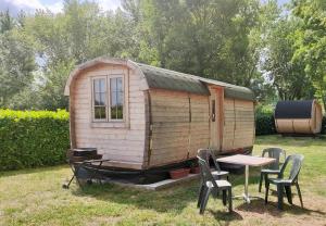 mały drewniany dom ze stołem i krzesłami w obiekcie Camping Les Voiles Sur Grosne w mieście Savigny-sur-Grosne