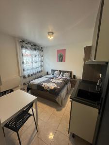 ein Schlafzimmer mit Bett und Tisch und eine Küche in der Unterkunft Charmant & LUXURY studio Paris Montreuil in Montreuil + 37 Fotos