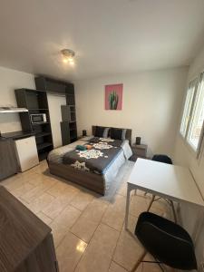 ein Schlafzimmer mit einem Bett und einem Tisch und Stühlen in der Unterkunft Charmant & LUXURY studio Paris Montreuil in Montreuil