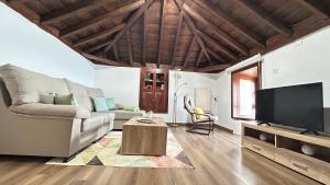 een woonkamer met een bank en een tv bij Casa Maruca in Puntagorda