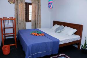 a bedroom with a bed with a blue table cloth at Mountain Breeze Inn Midigama in Midigama