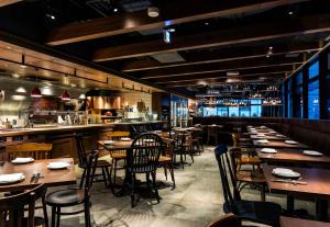 a restaurant with wooden tables and chairs and a bar at Daiwa Roynet Hotel Ginza PREMIER in Tokyo
