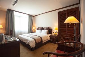 Rúm í herbergi á Rich Garden Hotel