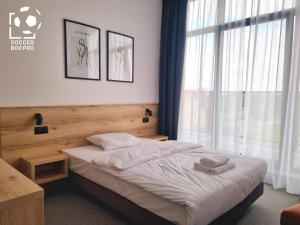 a bedroom with a bed and a large window at Soccer Box Pro in Dachnów +24 photos
