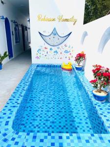 una piscina con suelo de baldosa azul y un cartel en Robinson Homestay - Cù Lao Mái Nhà, en Tuy An