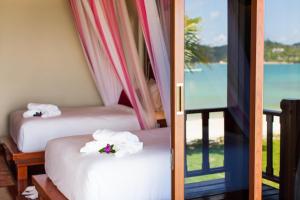 two beds in a room with a view of the ocean at PingChan Koh Phangan Beachfront Resort in Thong Nai Pan Yai