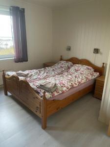 1 dormitorio con cama de madera y colcha de flores en Hokland Panorama, en Ånstad