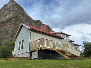 Una casa con un porche de madera y una montaña. en Hokland Panorama, en Ånstad