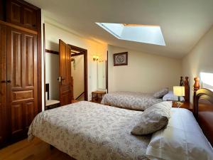 a bedroom with two beds and a skylight at Casa Rural Las Condesas in Santo Domingo de Silos