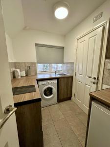 a kitchen with a washing machine and a washer at Lancaster Apartment in Leicester +11 photos