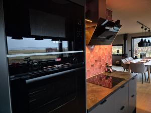 a kitchen with black cabinets and a view of the ocean at Villa Walter Lofoten with SAUNA in Kvalnes