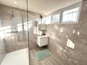 un baño con ducha y lavabo en Cozy Station House & Direct Access to Paris, en Bondy