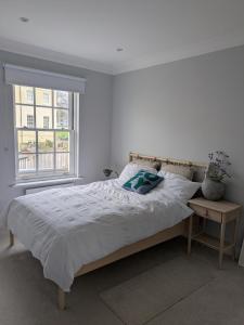 a white bedroom with a bed and a window at Modern townhouse in Mountwise in Plymouth