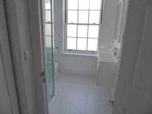 a white bathroom with a window and a sink at Modern townhouse in Mountwise in Plymouth +15 photos