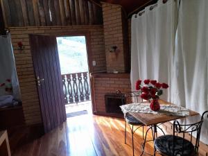 ein Zimmer mit einem Tisch mit einer Blumenvase darauf in der Unterkunft Paraíso da serra visconde de Mauá in Visconde De Maua