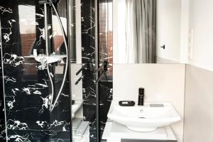 a black and white bathroom with a sink and a shower at Im Ort Übernachten in Warendorf