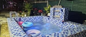 a small blue tiled swimming pool in a backyard at Redhousehomestay in Kota Bharu
