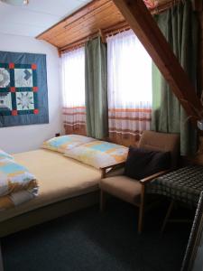 - une chambre avec 2 lits, une chaise et des fenêtres dans l'établissement Guest House U Lakomce, à Desná