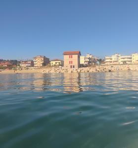 een waterlichaam met een stad op de achtergrond bij Il Casello nel mar in Civitanova Marche +27 foto's