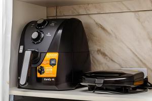 einem schwarzen Toaster, der auf einem Regal sitzt in der Unterkunft Casa de condomínio HP2 - Ideal para turistas e empresas - 7 min de carro das praias Tupi e Ocian in Praia Grande + 30 Fotos