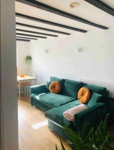 Una sala de estar con un sofá verde y una mesa. en Cozy Central Flat Oxford, en Oxford 1 foto más